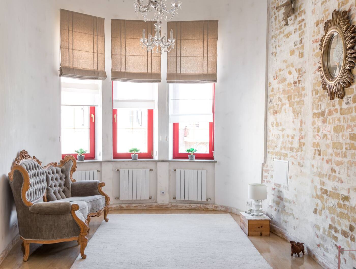 Before: the living room at intake, with damaged plaster and worn floors.